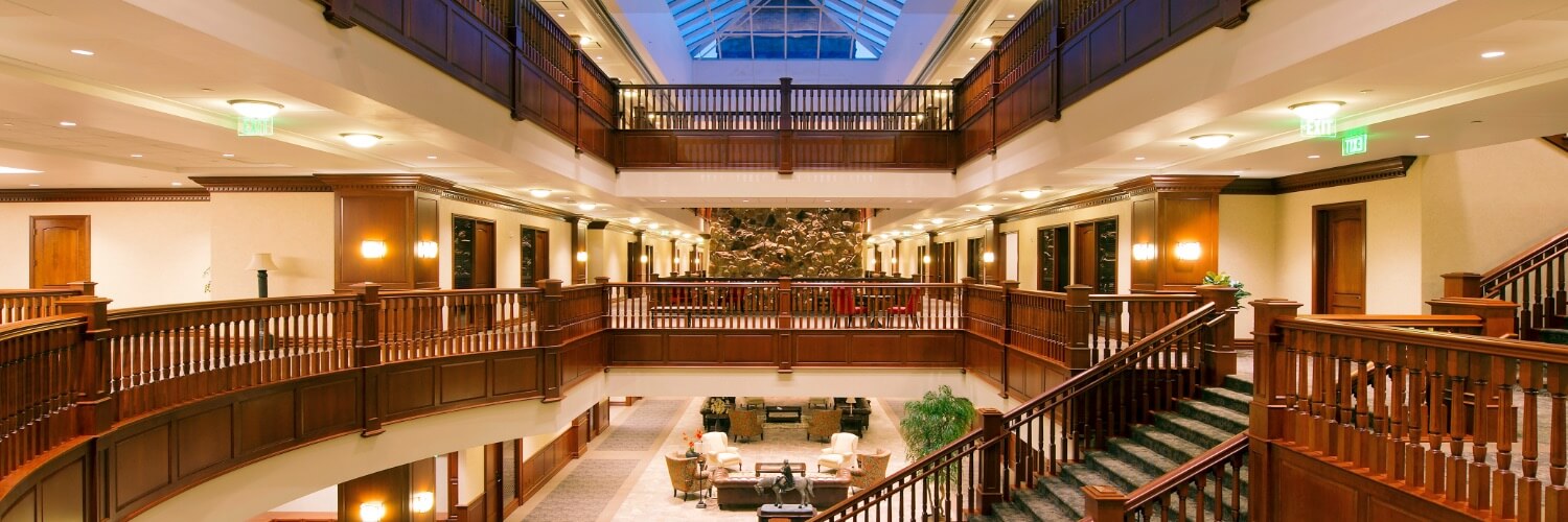 Interior atrium of the Melaleuca corporate headquarters in Idaho Falls, showing the grand staircase and multi-story wood balconies