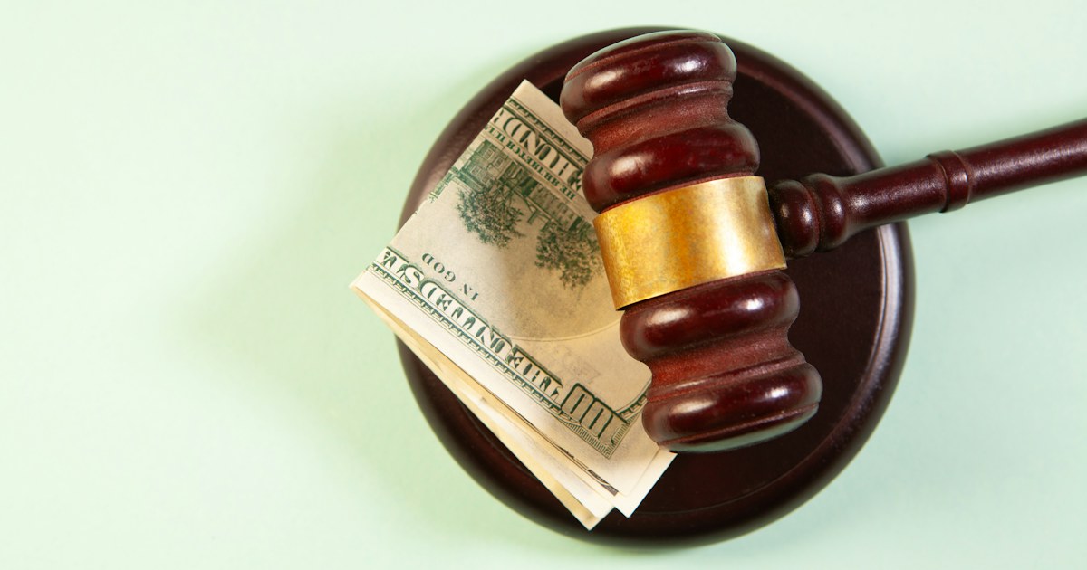 Gavel resting on cash, illustrating how far behind in child support before a warrant is issued