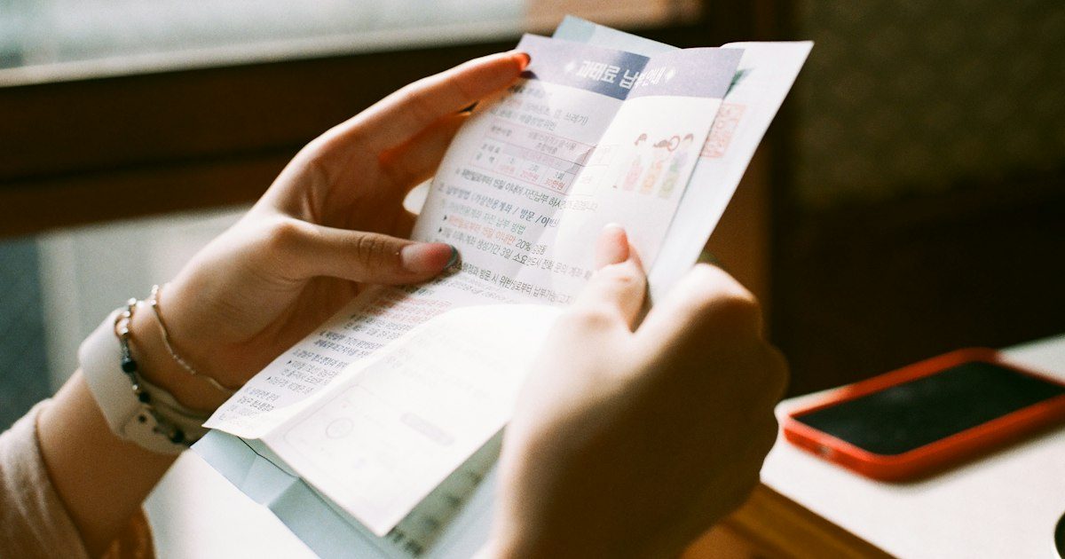 Person reading a printed bill at home, illustrating medical bills in collections